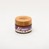 Amber jar of Impact Botanicals Cellulite Firming Cream with a bamboo lid.