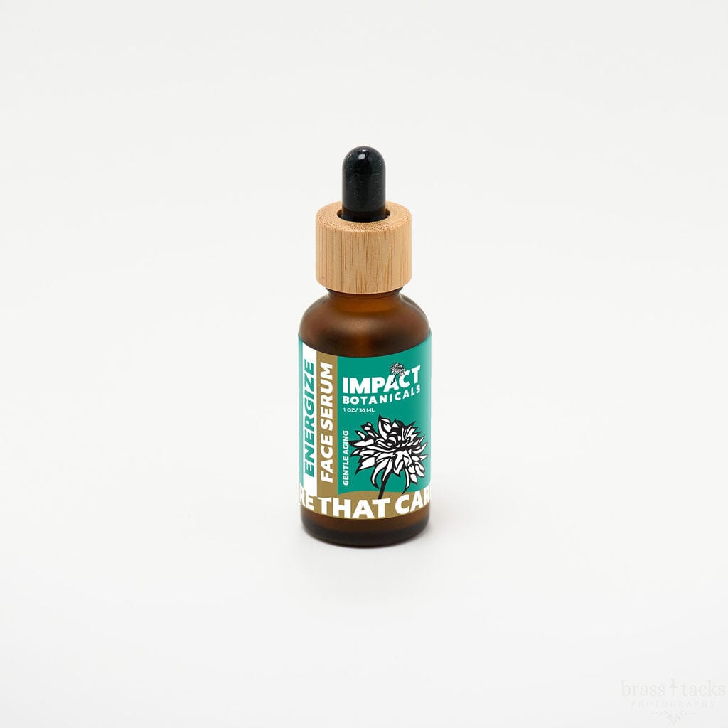 Amber glass bottle of Impact Botanicals Energize Face Serum with bamboo dropper top on white background.