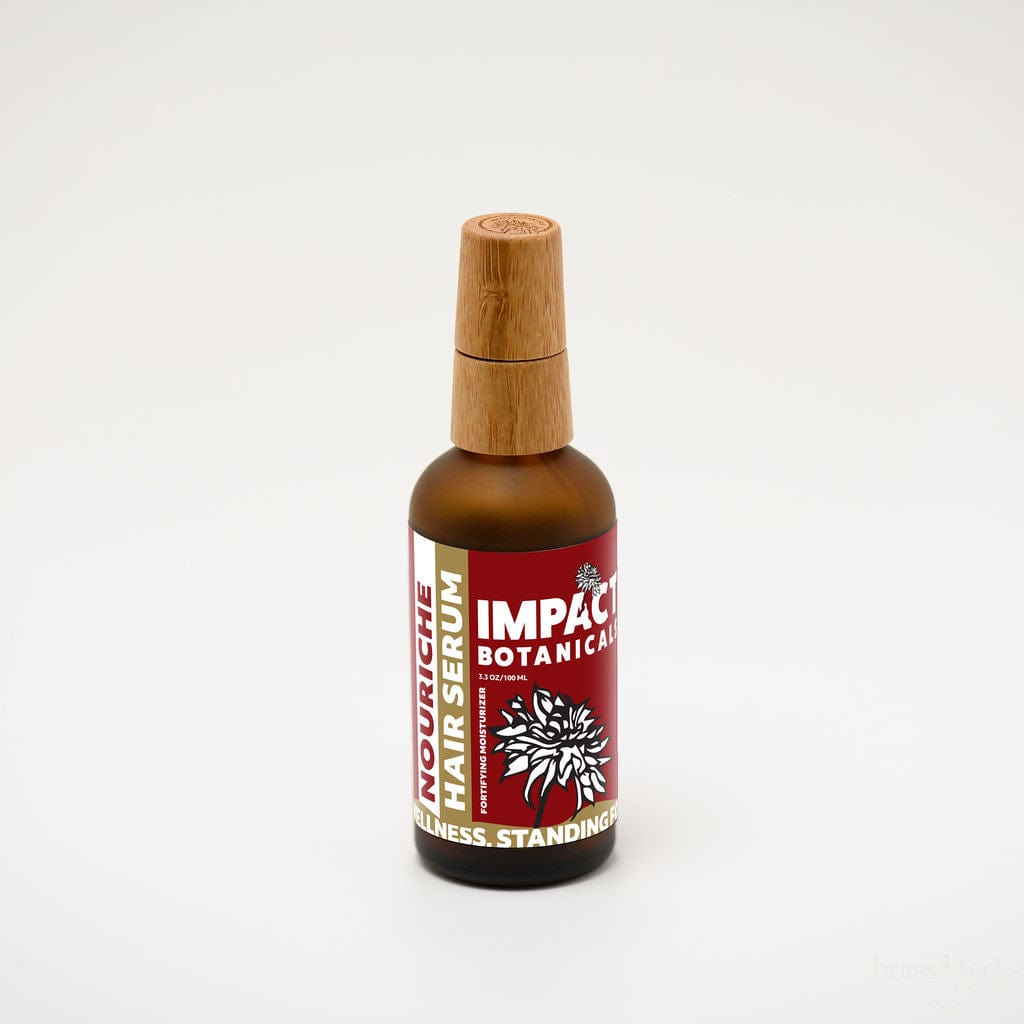 Nourishe Hair Serum by Impact Botanicals in amber bottle with bamboo cap.
