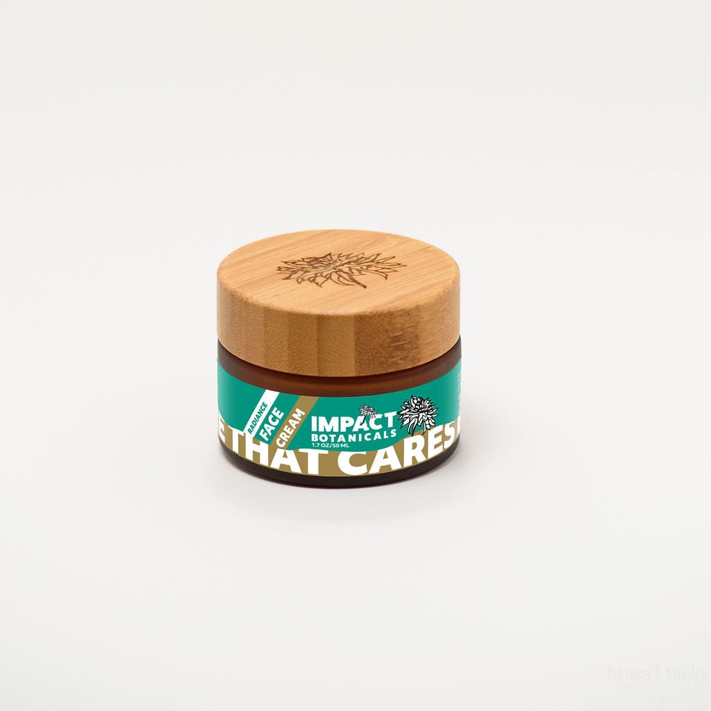 Amber jar of Impact Botanicals Radiance Face Cream with a bamboo lid, set on a white background.
