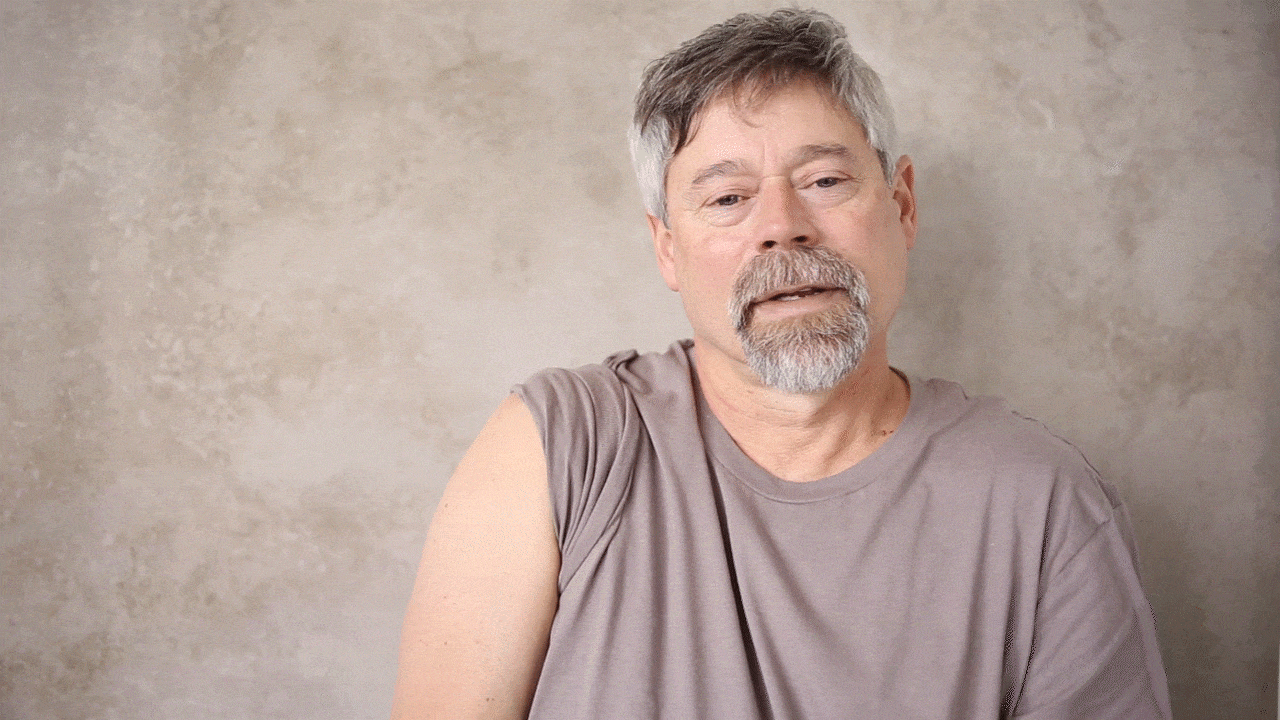 "Man with gray hair and goatee displays his bare arm after receiving a vaccination."